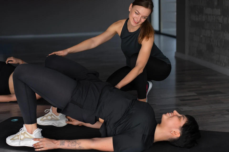 A therapist guiding a patient through an assisted leg exercise.
